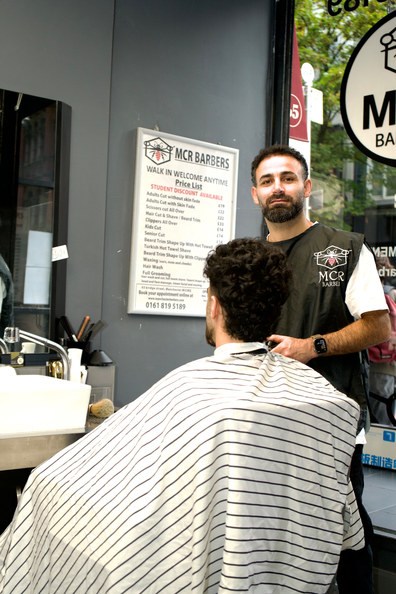 Two barber stations with tall mirrors, white basins and black leather chairs